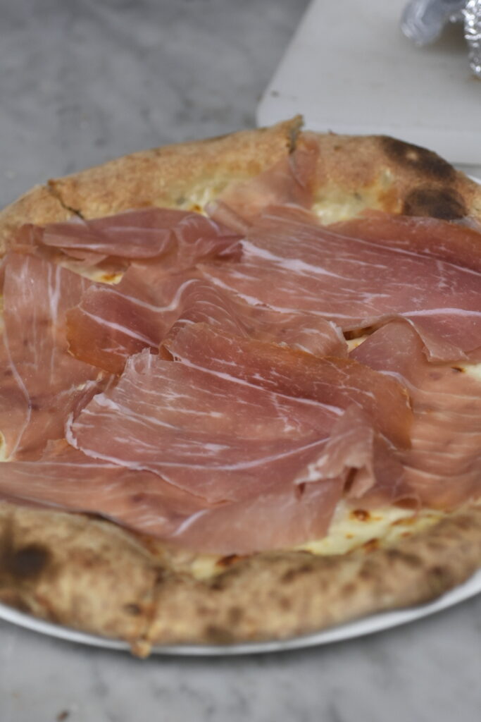 Pizza me proshute krudo ne pergatitje e siper.