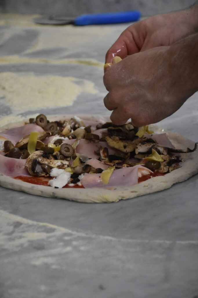 Pizza Kapricoze me Proshute Italiane, Ullinj, Mozzarella dhe Speca duke u pergatitur ne ambientet e 3DDDI.